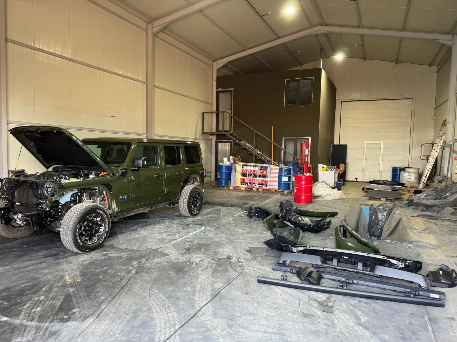 Jeep cu partea frontală demontată și piese pregătite pentru protecție Bullet Liner.