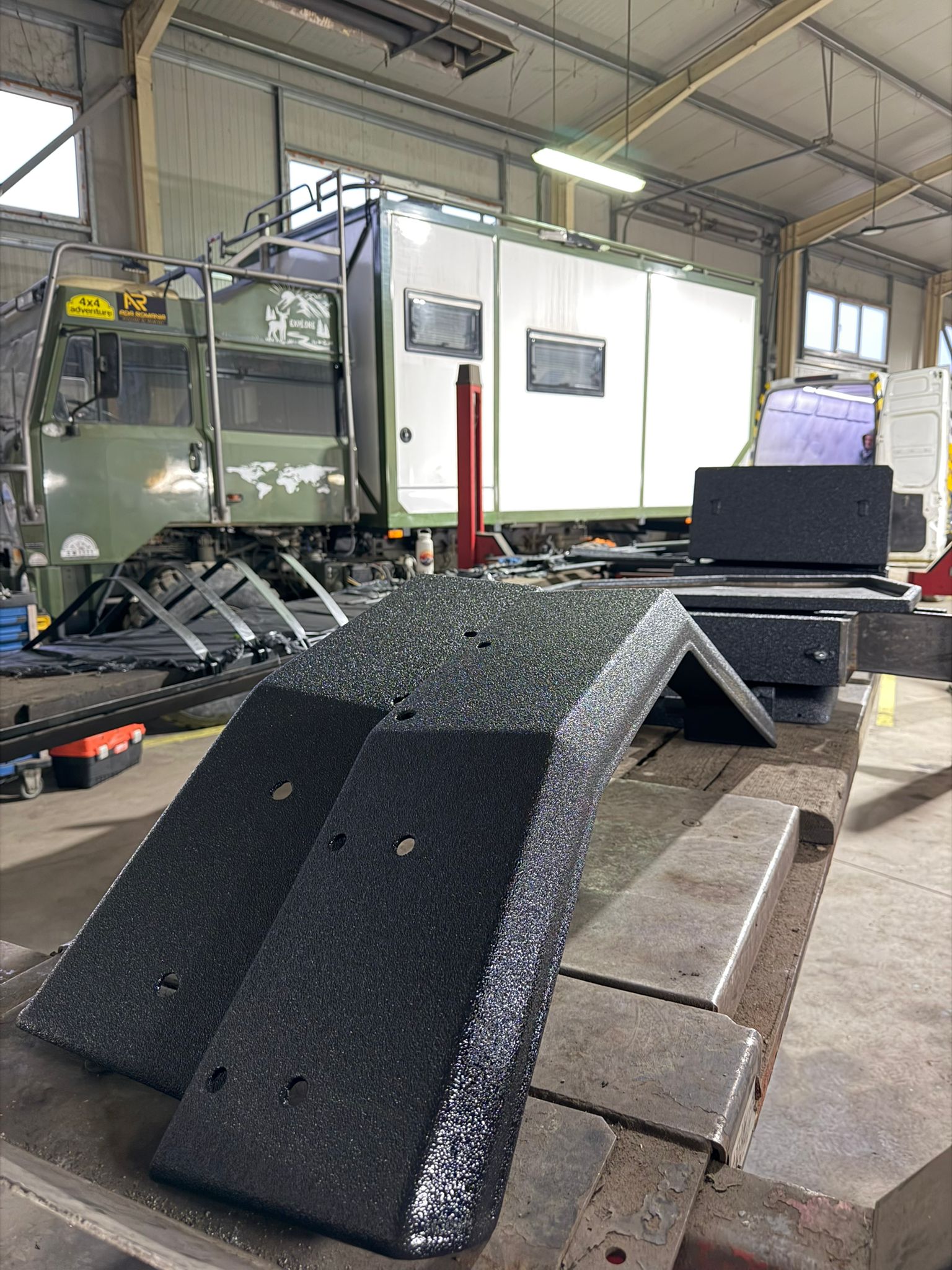 Piese 4x4 protejate Bullet Liner, pregătite pentru montaj într-un atelier de expediție.