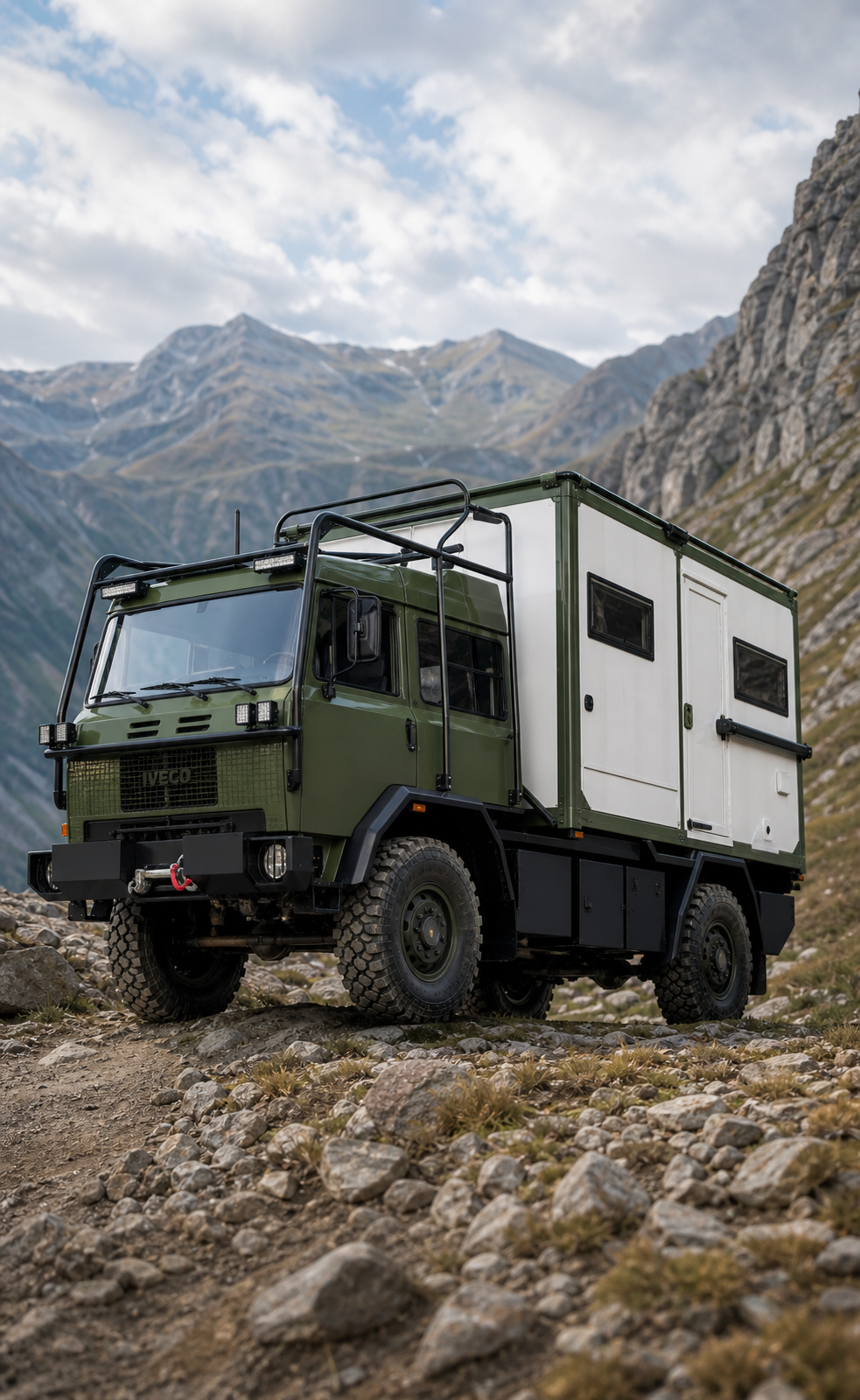 Camion expediție 4x4 pe teren montan accidentat, cu zone tratate Bullet Liner pentru utilizare offroad reală.